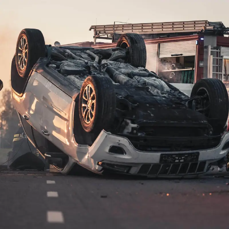 Car accident scene with overturned vehicle on road, highlighting dangers of distracted or drunk driving, relevant to personal injury claims in Harris County, Texas.