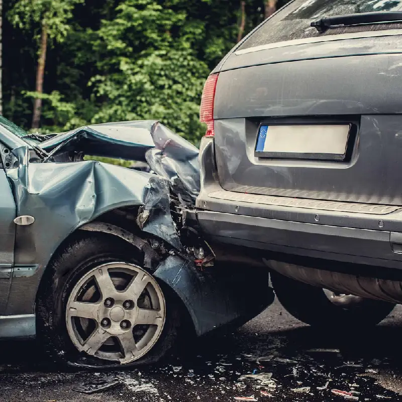 Rear-end collision between a damaged sedan and an SUV, illustrating the impact of distracted driving and potential neck and back injuries.