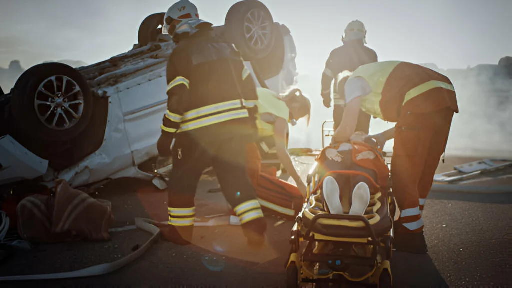 Emergency responders assisting injured individuals at a multi-vehicle accident scene with an overturned car, emphasizing the importance of legal support for personal injury victims in Hunt County.