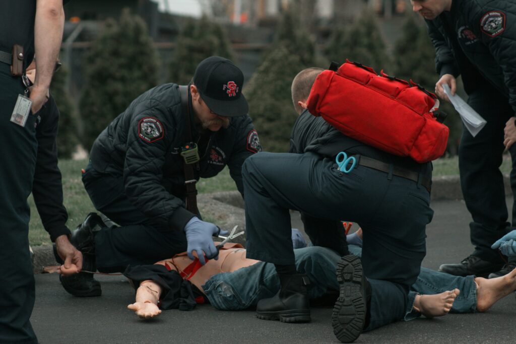 Emergency responders attending to a simulated injury with a training mannequin, emphasizing personal injury scenarios relevant to legal claims in South Dallas.