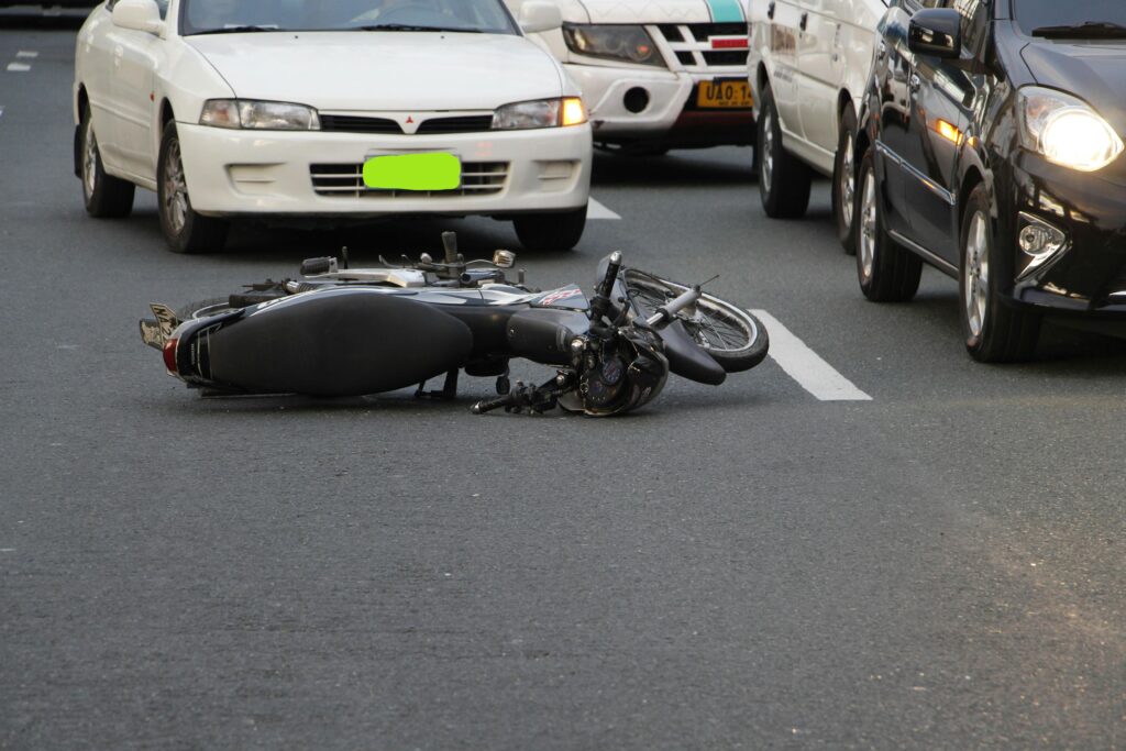 Motorcycle accident scene on a busy road with a fallen bike and surrounding vehicles, illustrating the aftermath of an injury incident relevant to personal injury claims in Bellaire, Texas.